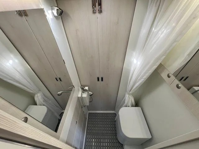 Bad von oben: Duschwanne mit Rost, Trenntoilette, Spiegel und Duschvorhang